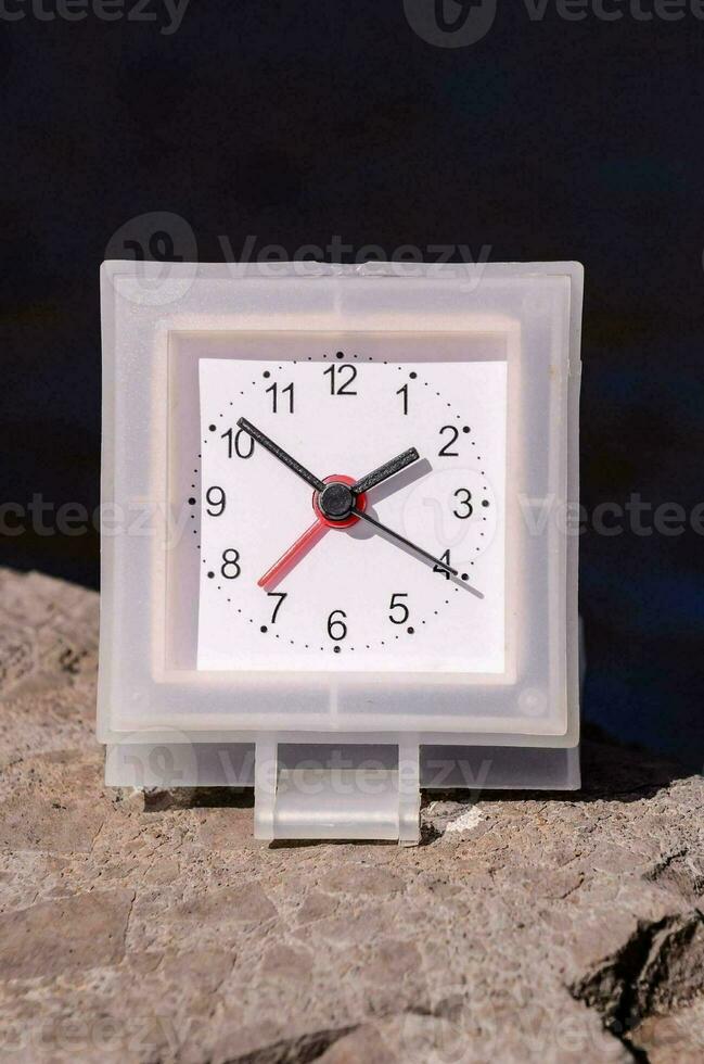 ein Uhr auf ein Felsen foto