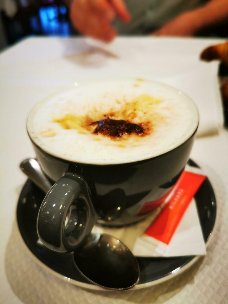 Foto von ein köstlich Tasse von Cappuccino auf ein Untertasse mit Löffel