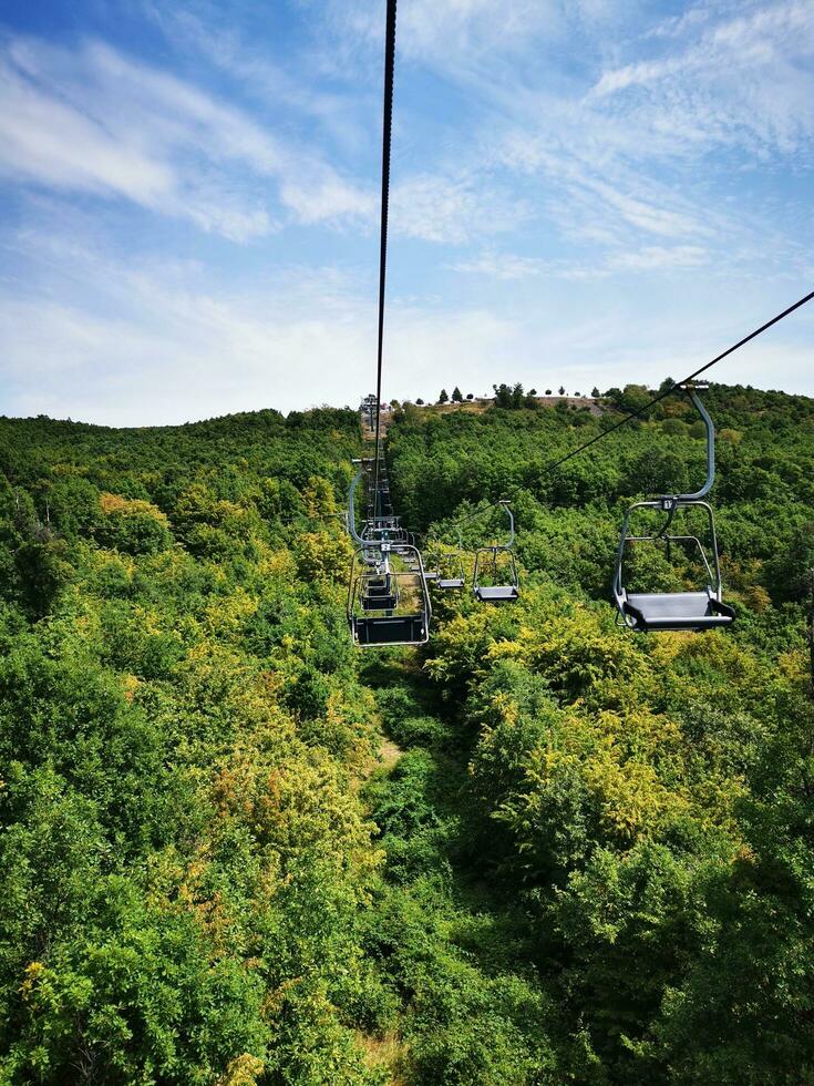 Foto von ein Ski Aufzug Reiten Über ein schön Grün Hang