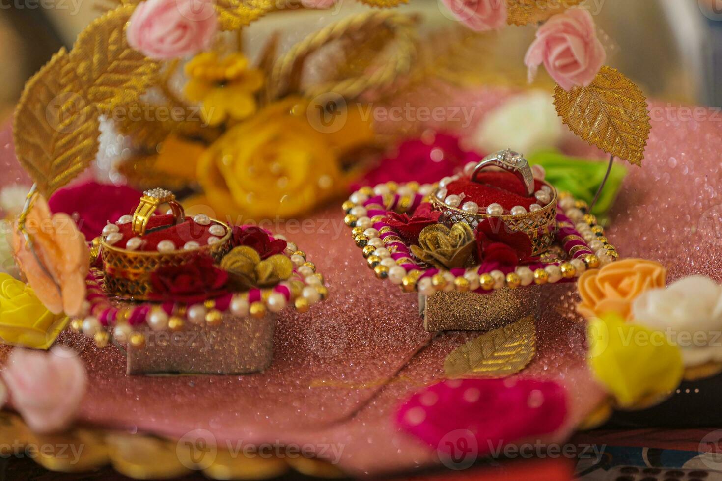 Hochzeit Ringe im Hochzeit Zeremonie, indisch Hochzeit Ringe im ein öffnen Box auf traditionell Stil Girlande. foto