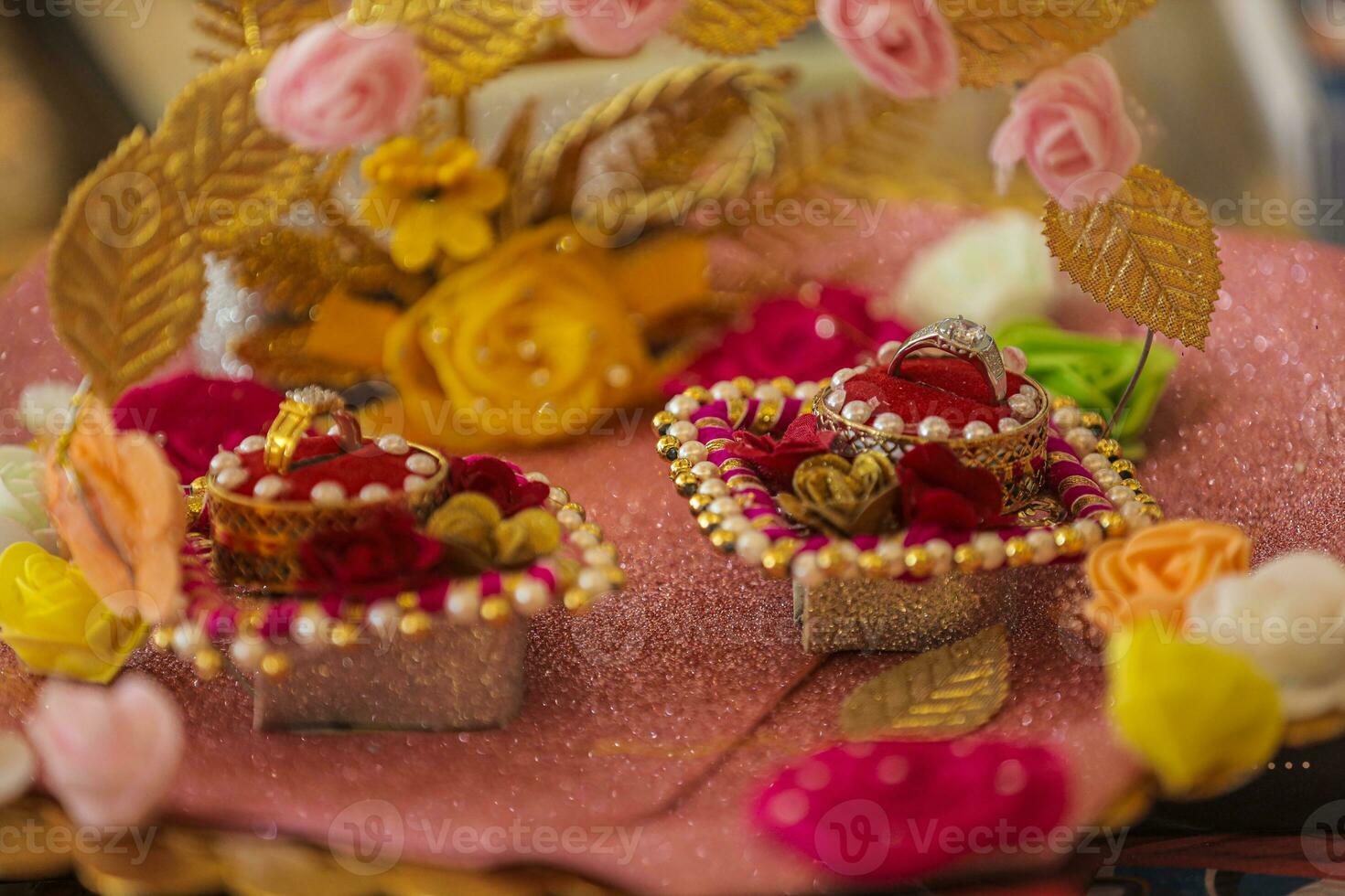 Hochzeit Ringe im Hochzeit Zeremonie, indisch Hochzeit Ringe im ein öffnen Box auf traditionell Stil Girlande. foto