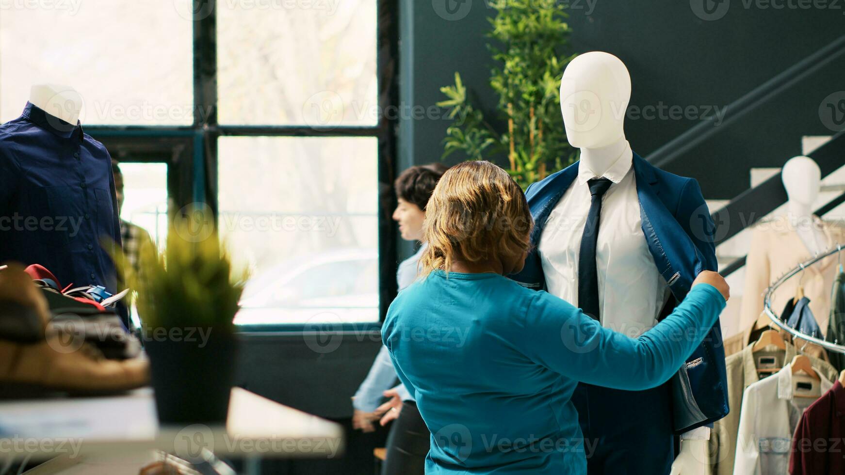 afrikanisch amerikanisch Klient suchen beim formal Anzug, Überprüfung Kleider Material im modern Boutique. Shopaholic Frau Einkaufen zum modisch Fan-Shop, Kauf stilvoll Shirt. Mode Konzept foto