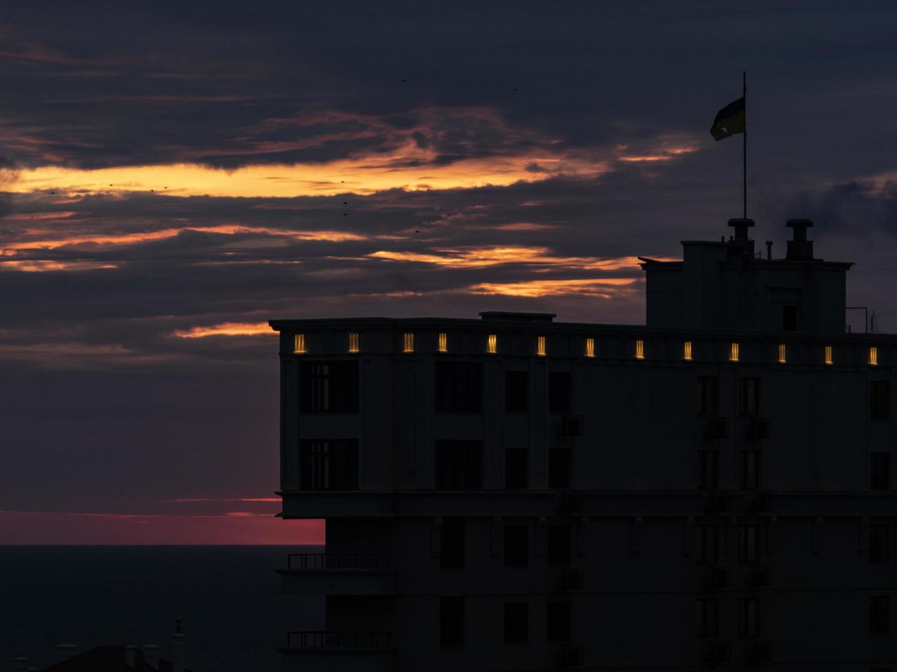 Silhouette eines Gebäudes mit einer Flagge auf dem Hintergrund eines Unrise foto