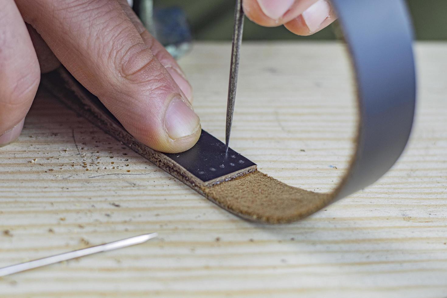 Handwerker macht echtes schwarzes Lederarmband foto