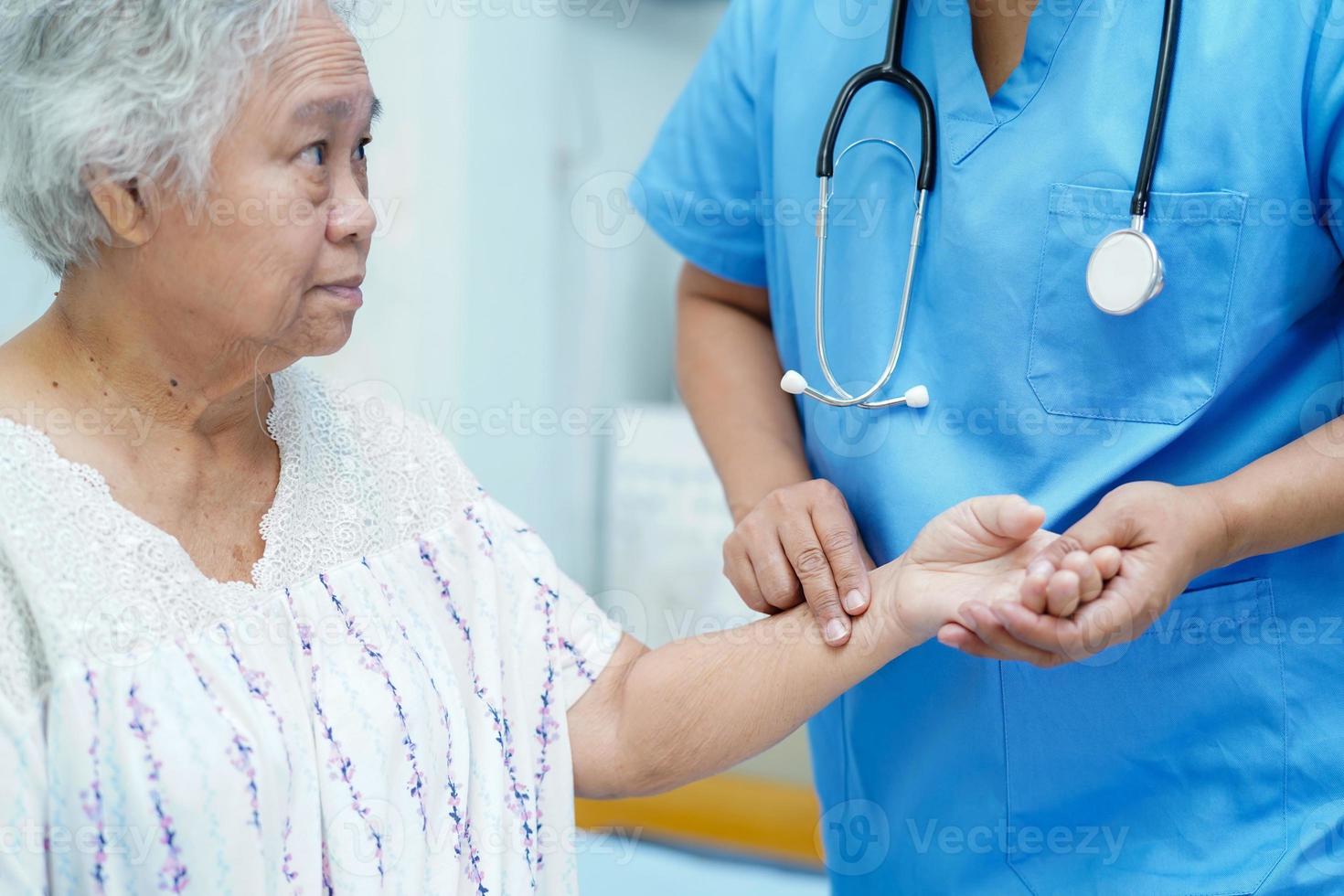 Arzt, der asiatische ältere Patientin im Krankenhaus überprüft. foto