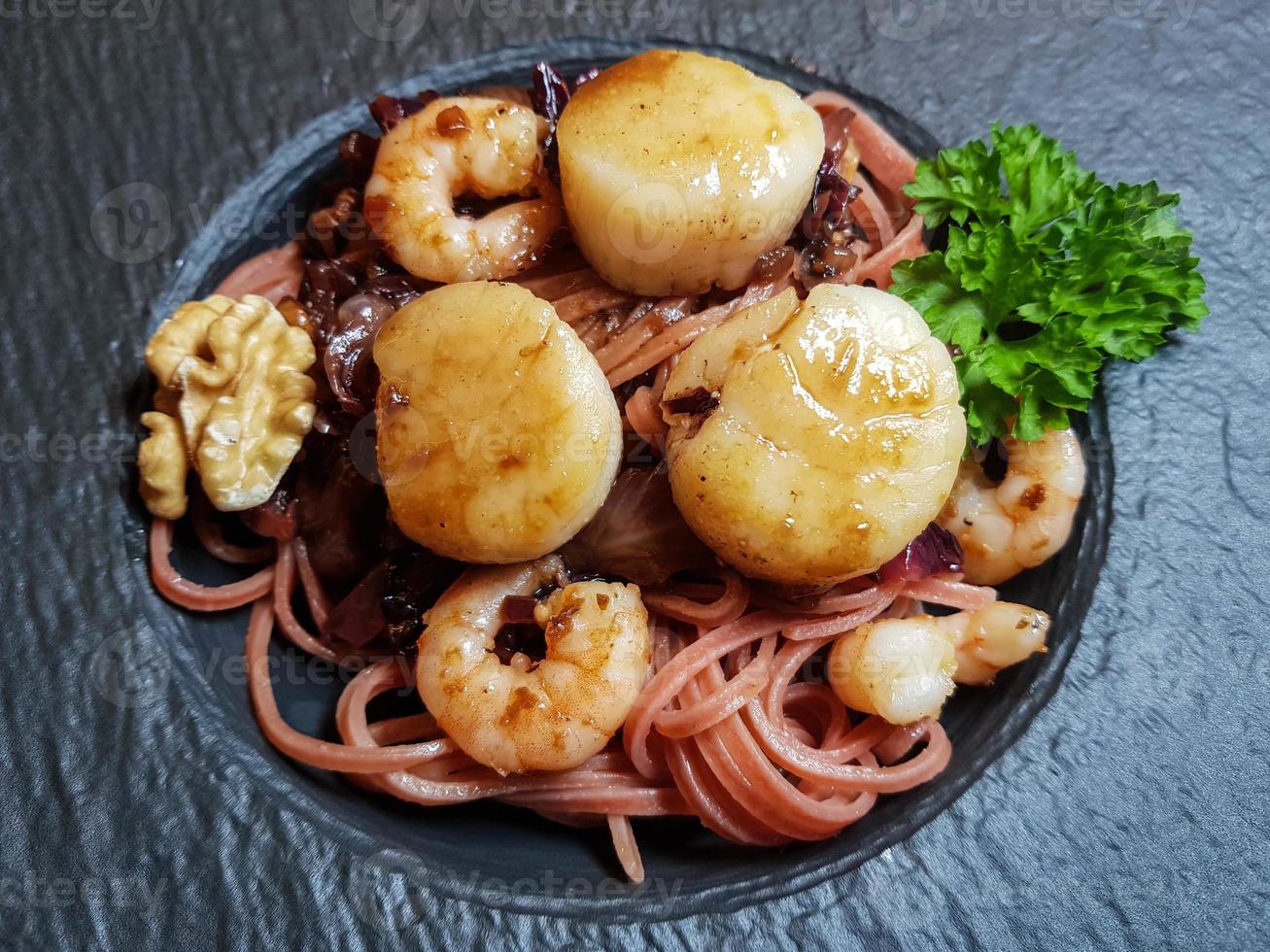 Jakobsmuscheln mit roten Linguine-Nudeln, Kräutern und Gewürzen foto