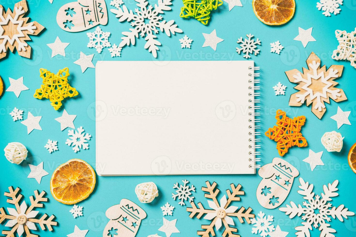 Draufsicht des Notebooks auf blauem Hintergrund mit Neujahrsspielzeug und Dekorationen. Weihnachtszeit-Konzept foto