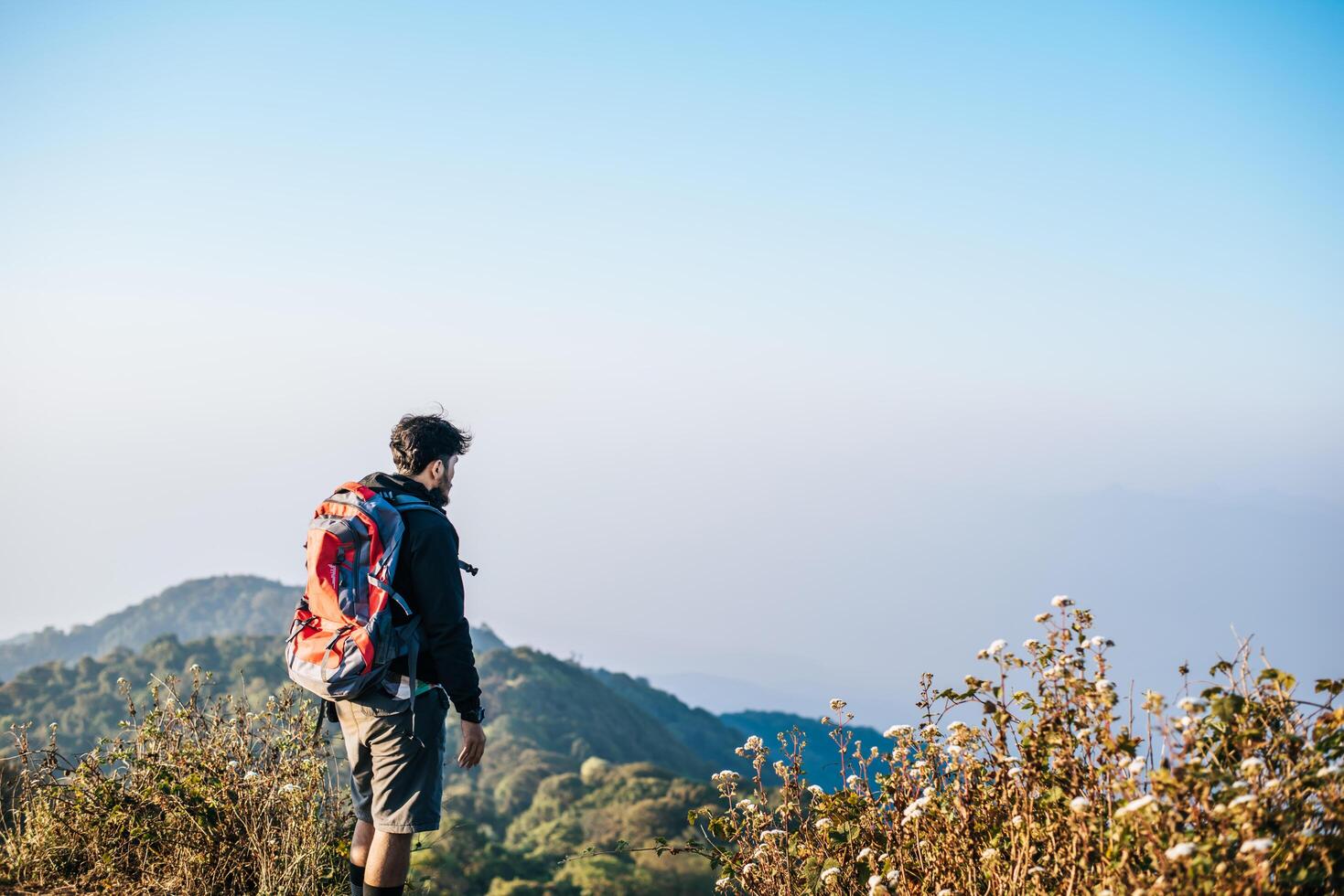 Mann reist mit Rucksack wandern in den Bergen foto