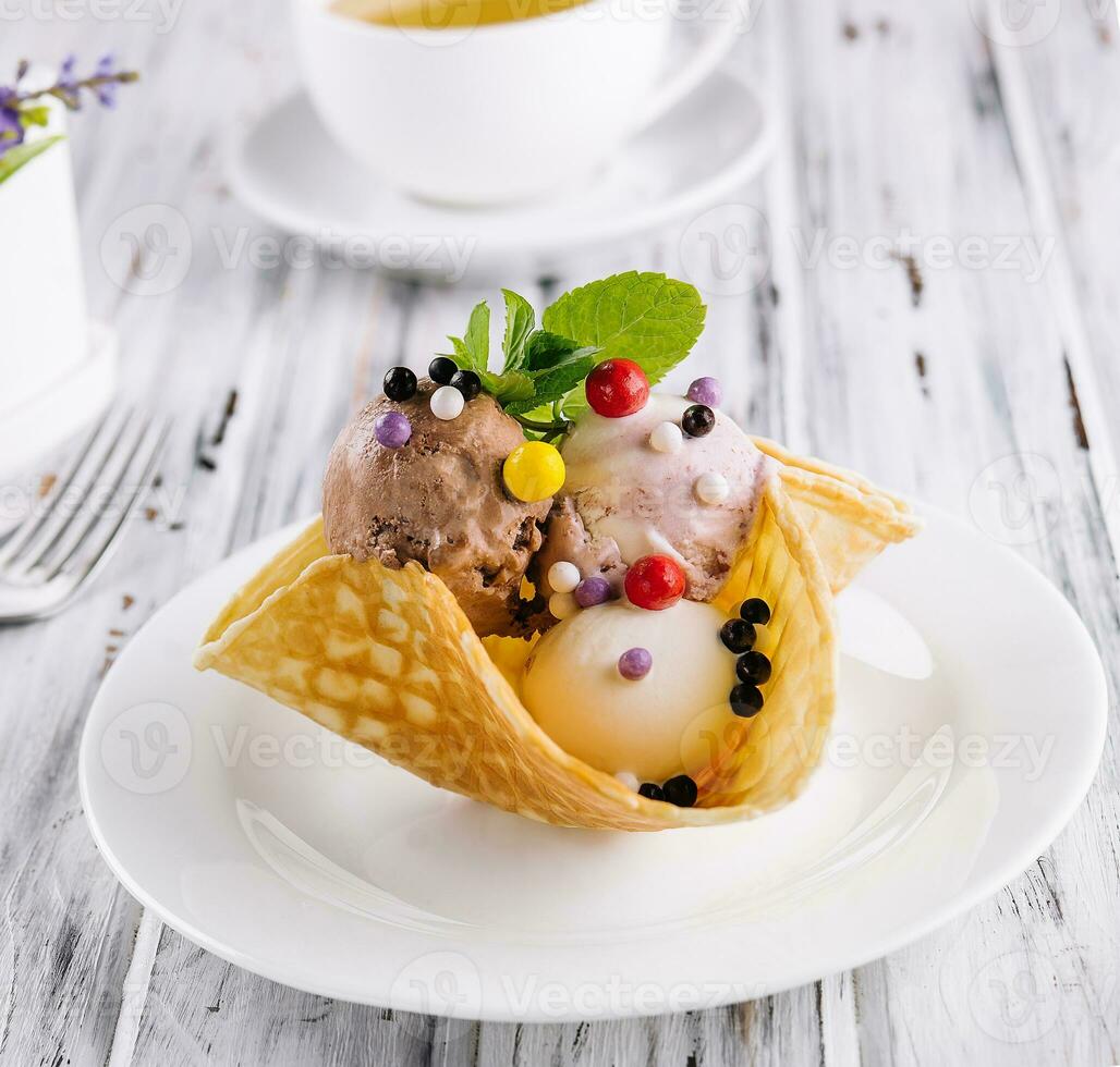 drei Schaufeln von natürlich organisch Obst Eis Sahne im ein Wafer Tasse foto