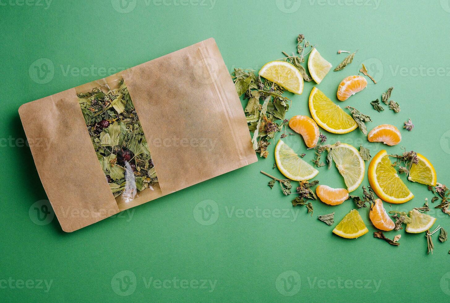 Blatt Tee verschüttet aus von ein Papier Paket mit Orange und Mandarine Scheiben foto