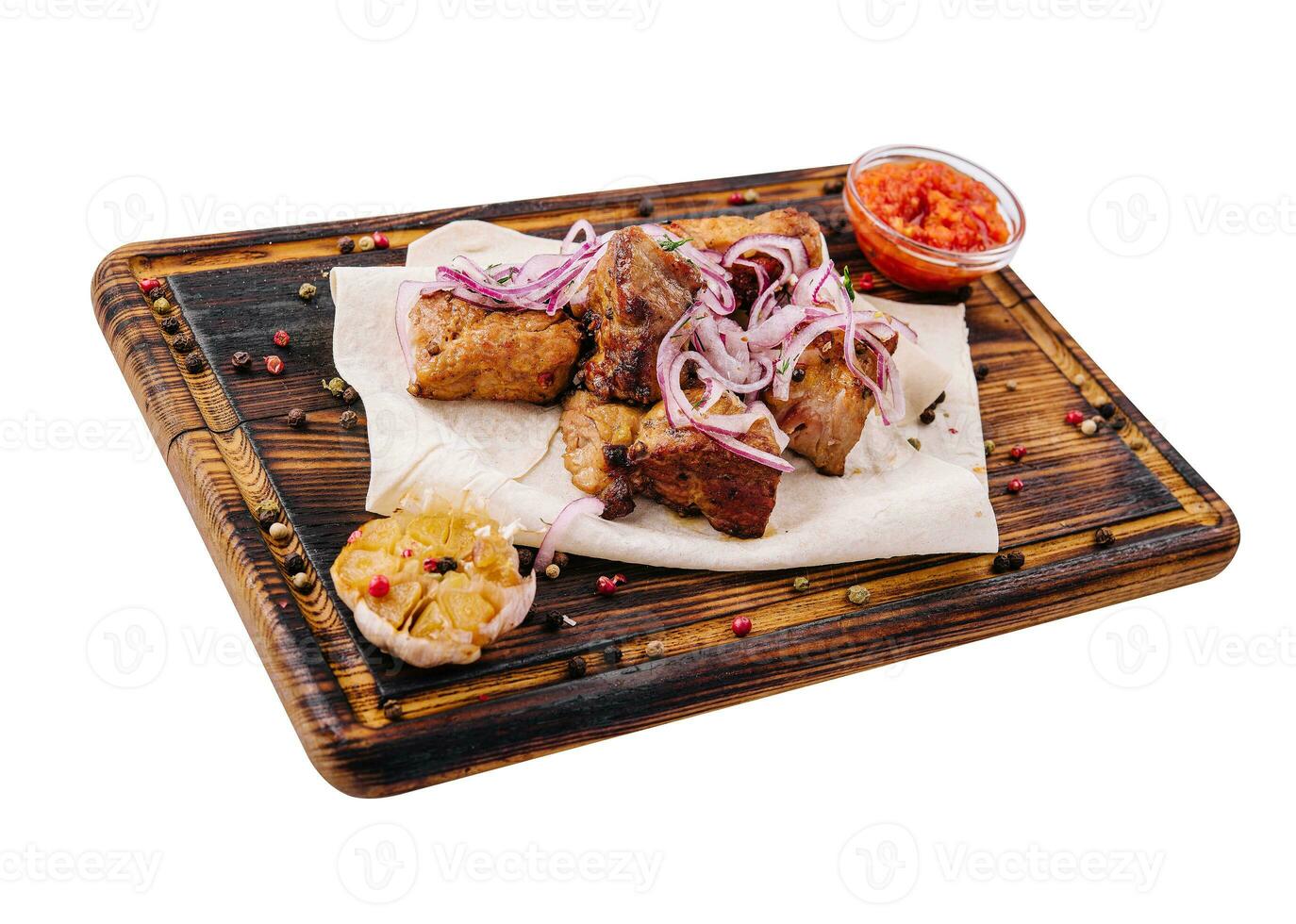 Portion von Grill mit Soße und eingelegt Zwiebeln auf ein hölzern Tafel foto