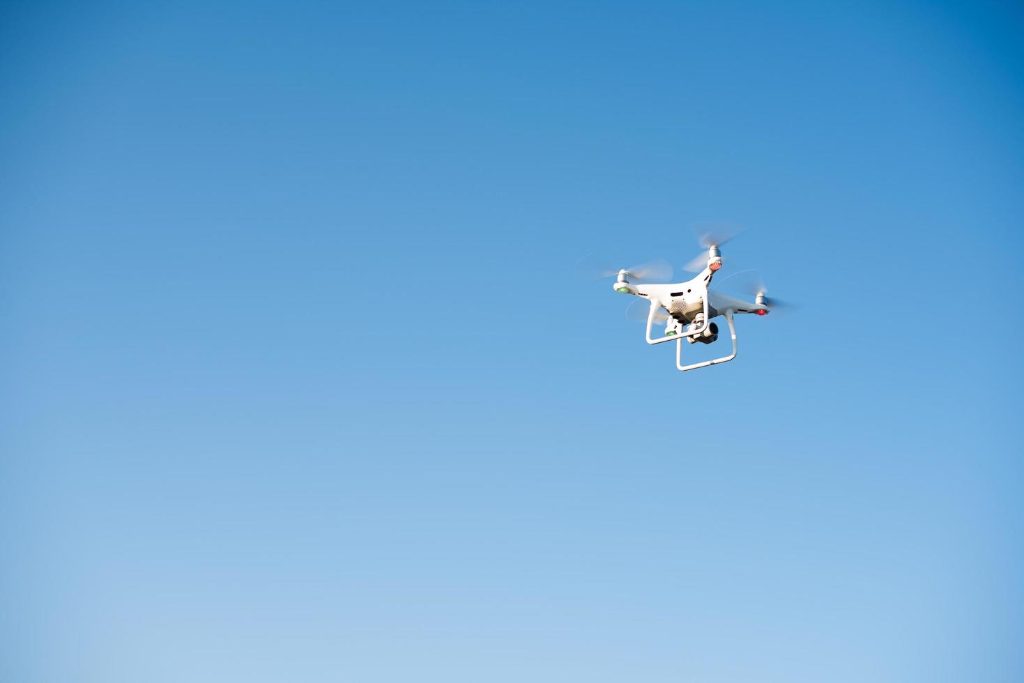 weiße Drohne fliegt in den Himmel und nimmt ein Video auf foto