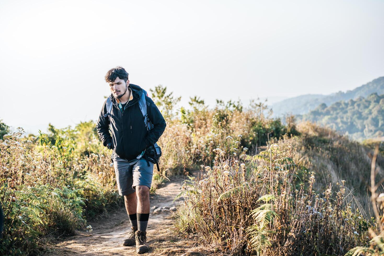 Mann reist mit Rucksack wandern in den Bergen foto