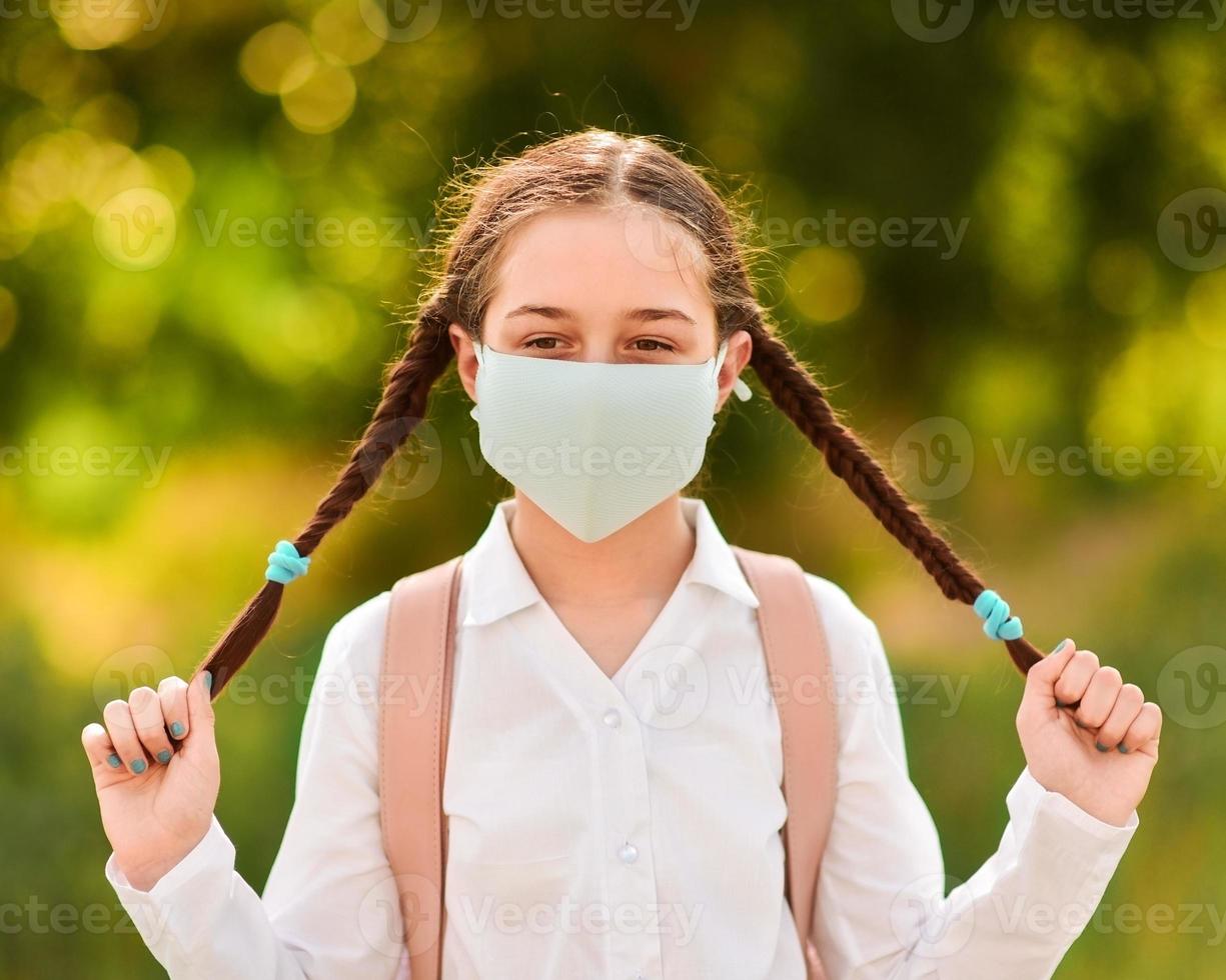 ein Mädchen in einer medizinischen Maske foto