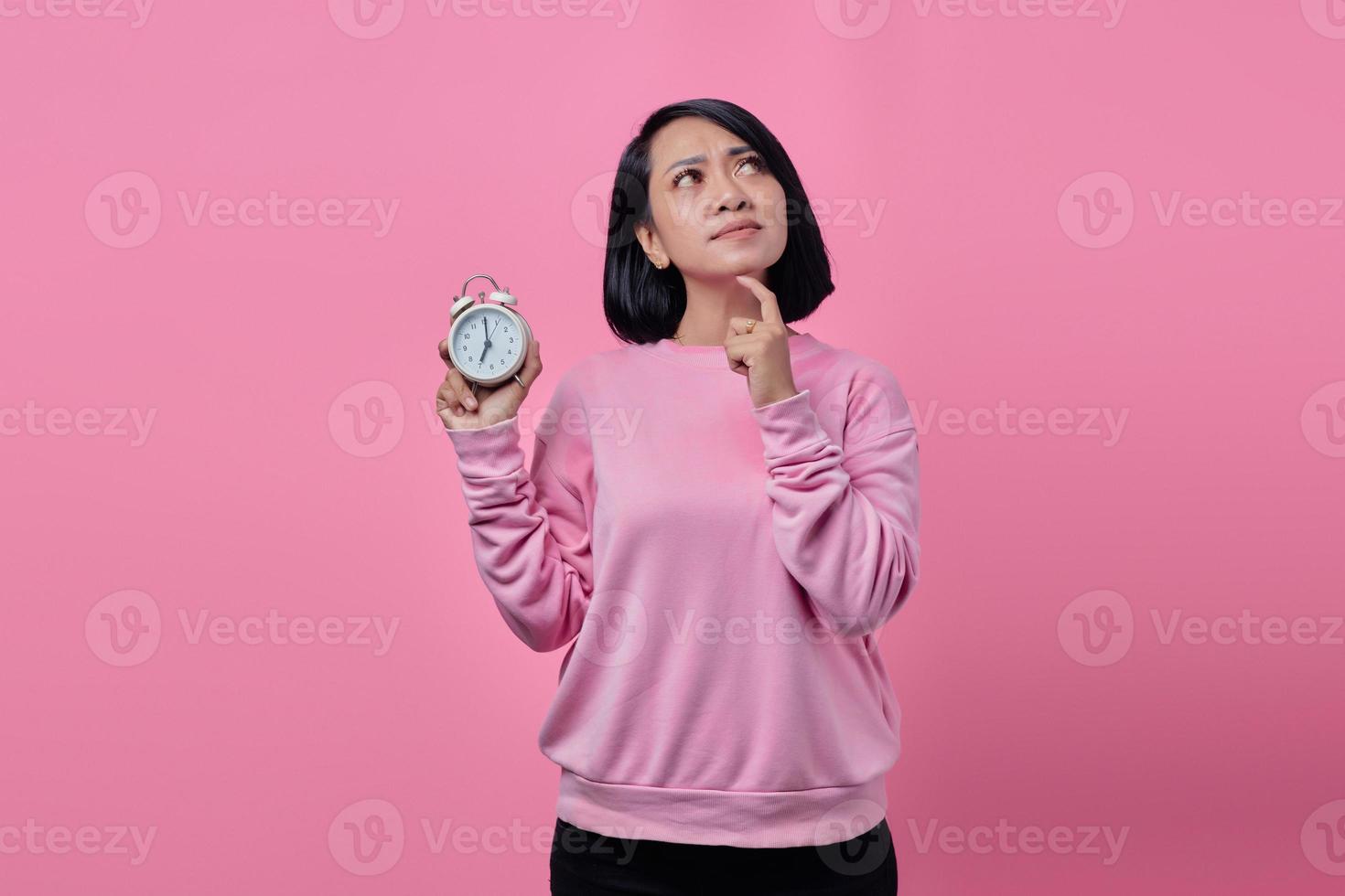 schöne junge Frau hält weißen Wecker in der Hand foto