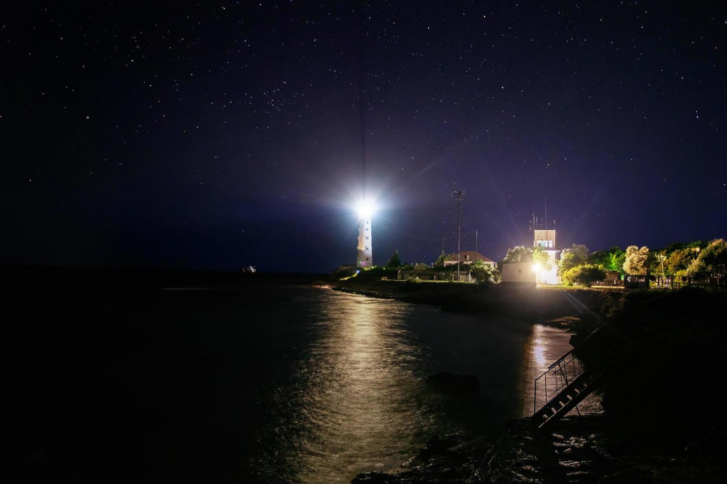 Leuchtturm an der Meeresküste bei Nacht foto