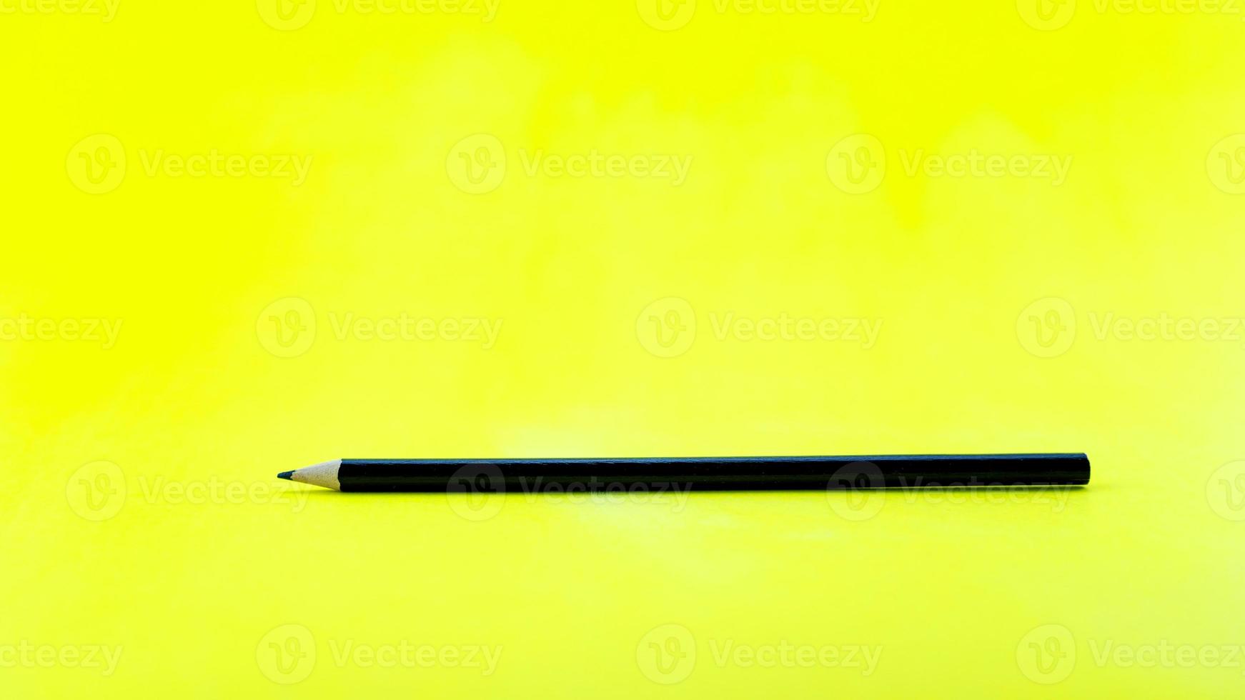 schwarzer Bleistift auf gelbem Papierhintergrund. foto