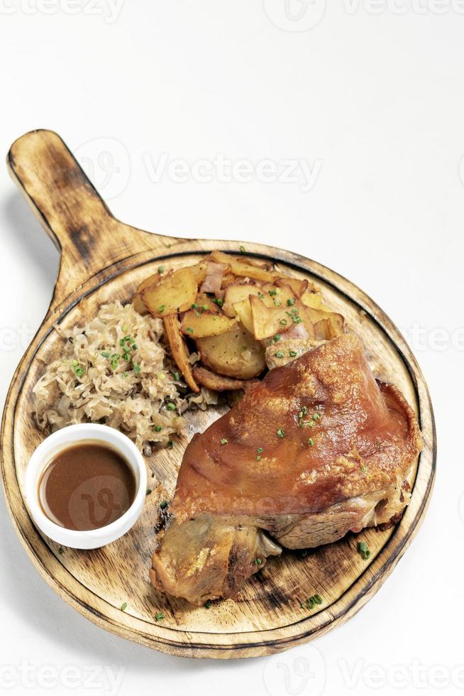 Schweinshaxe traditionelle deutsche Schweinshaxe mit Sauerkraut und Kartoffelmahlzeit auf weißem Hintergrund foto