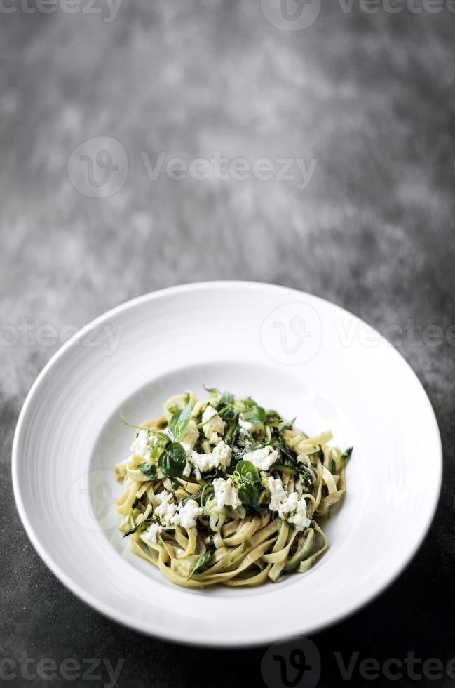 Gourmet italienischer Bio-Ricotta und frische gemischte Kräuter-Tagliatelle auf Teller foto