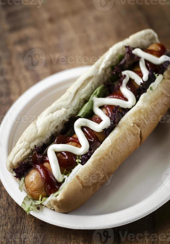 klassischer Hot Dog mit Frankfurter Würstchen und Saucen foto