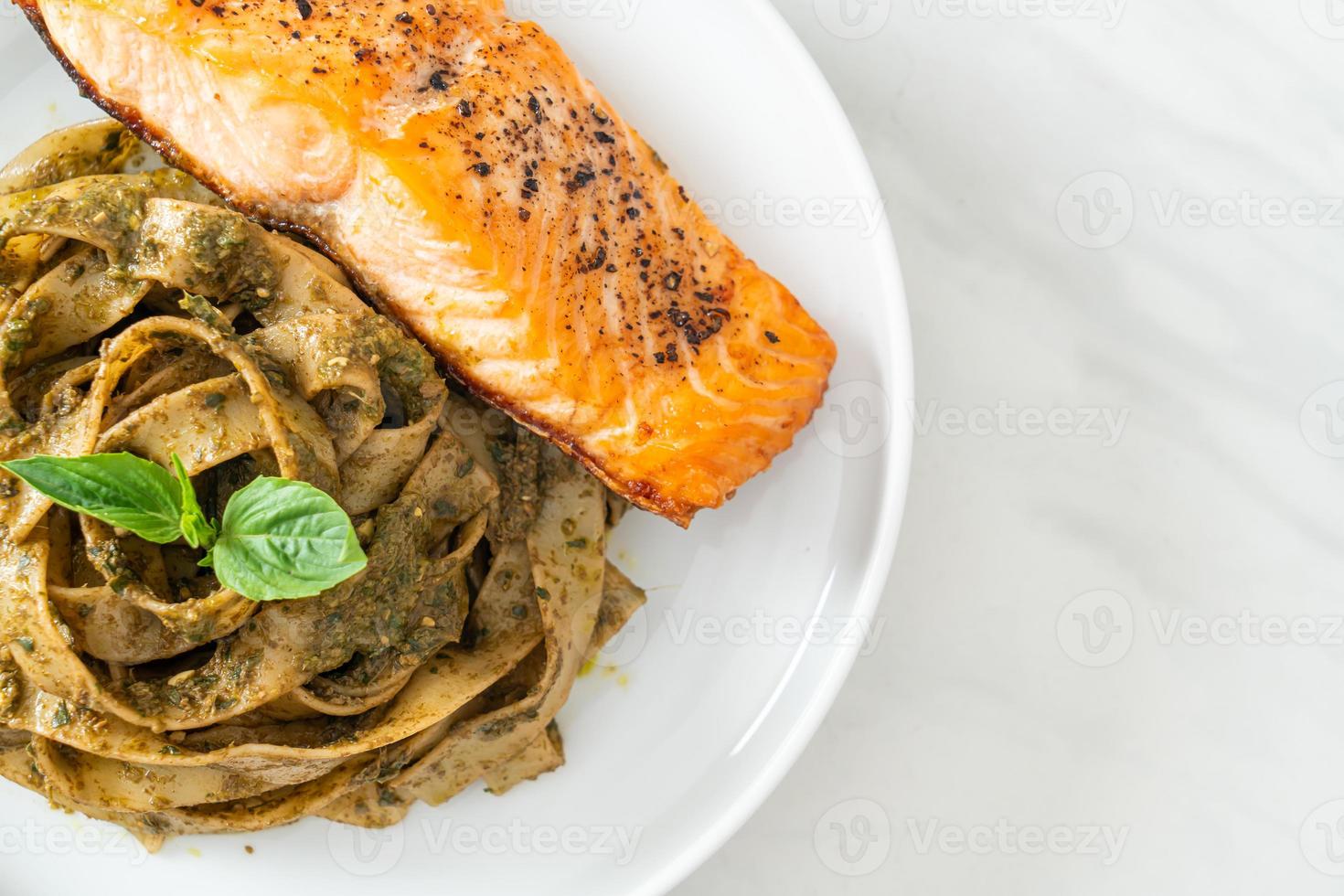 hausgemachte Pesto-Fettuccine-Spaghetti-Nudeln mit gegrilltem Lachsfilet foto