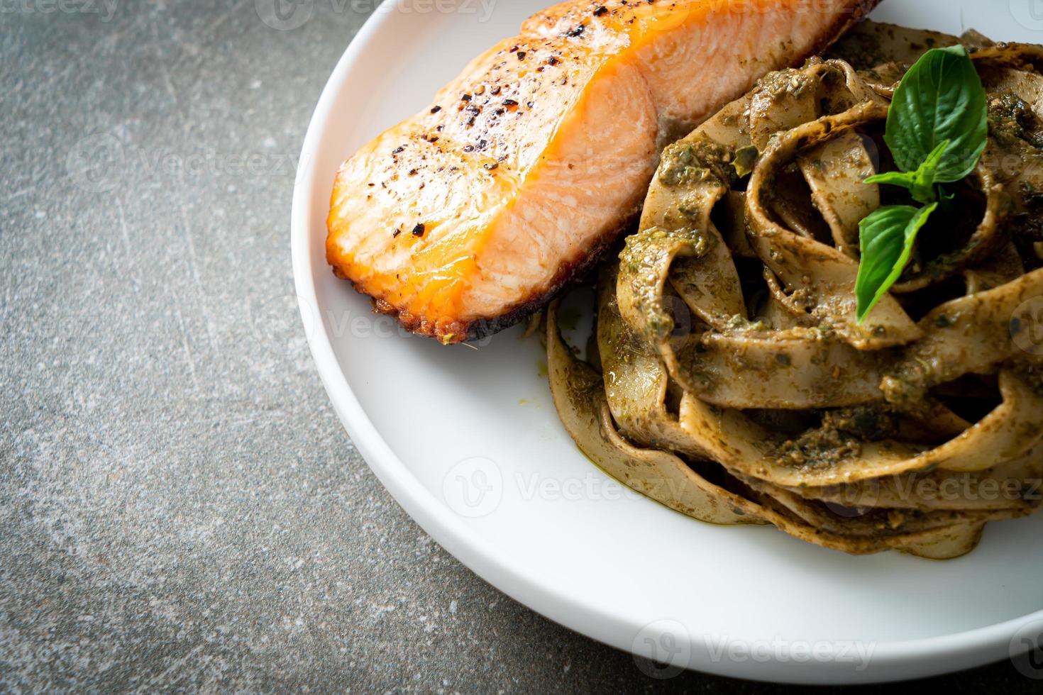 hausgemachte Pesto-Fettuccine-Spaghetti-Nudeln mit gegrilltem Lachsfilet foto