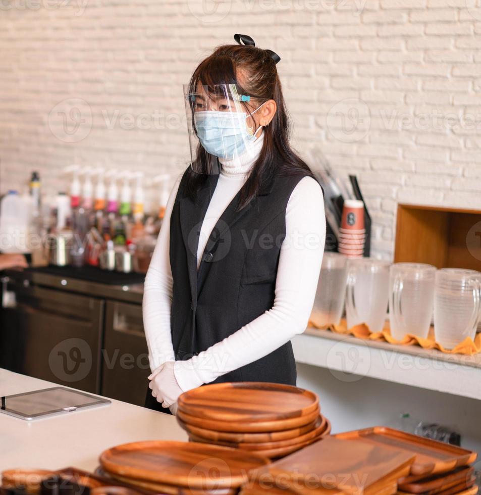 Coffeeshop-Geschäftsinhaber, der eine chirurgische Maske trägt. foto