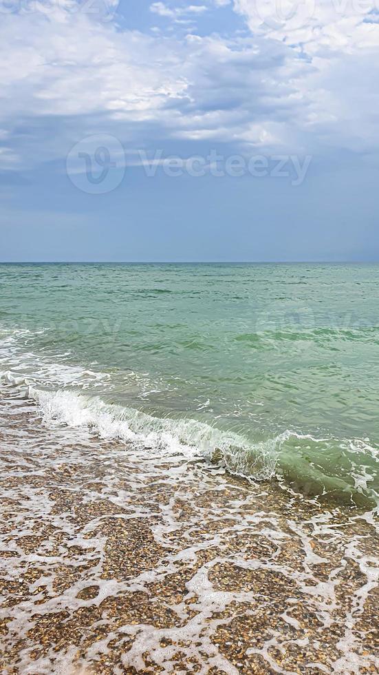 Seelandschaft. azurblaues Wasser, schäumende Wellen am Ufer. foto