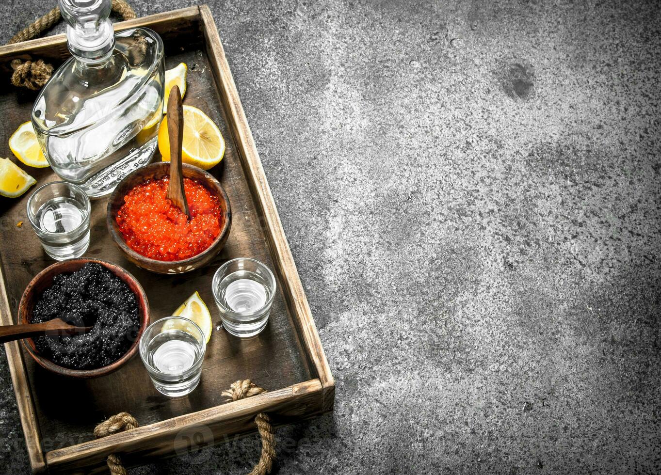 Wodka im ein Flasche mit schwarz und rot Kaviar . foto