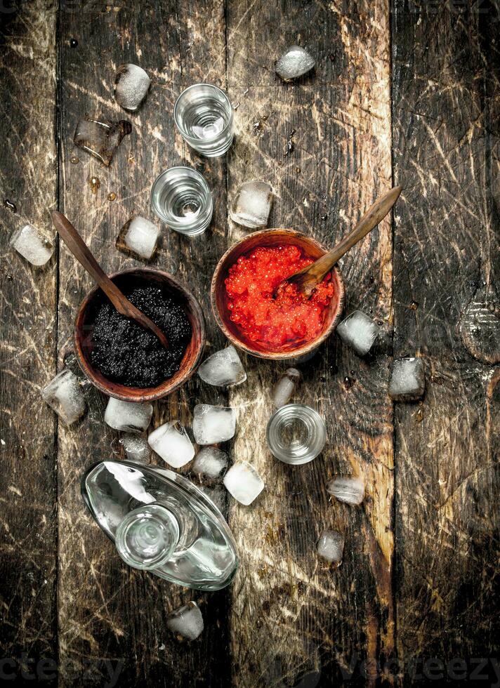 Wodka im ein Flasche mit schwarz und rot Kaviar. foto
