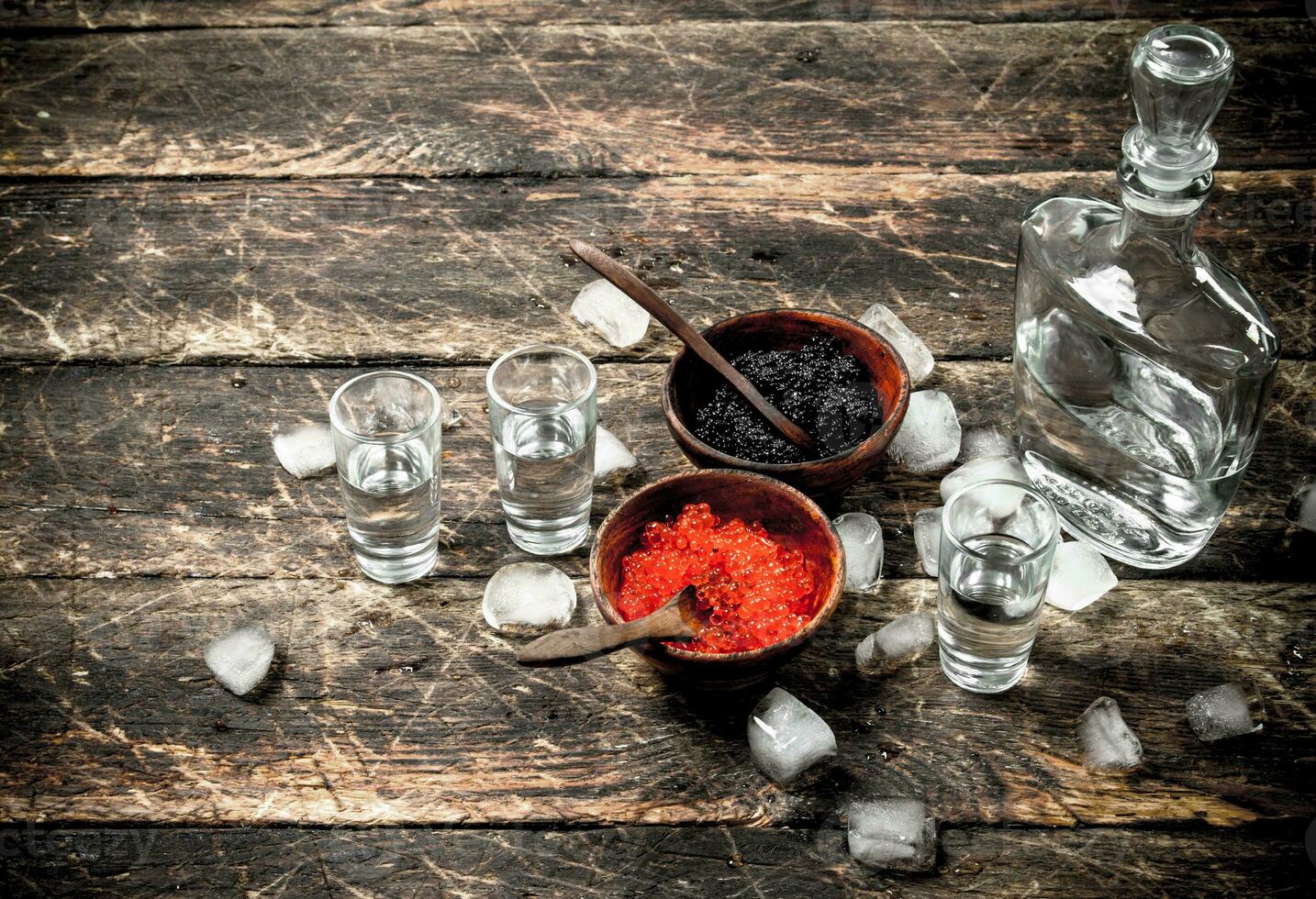 Wodka im ein Flasche mit schwarz und rot Kaviar. foto