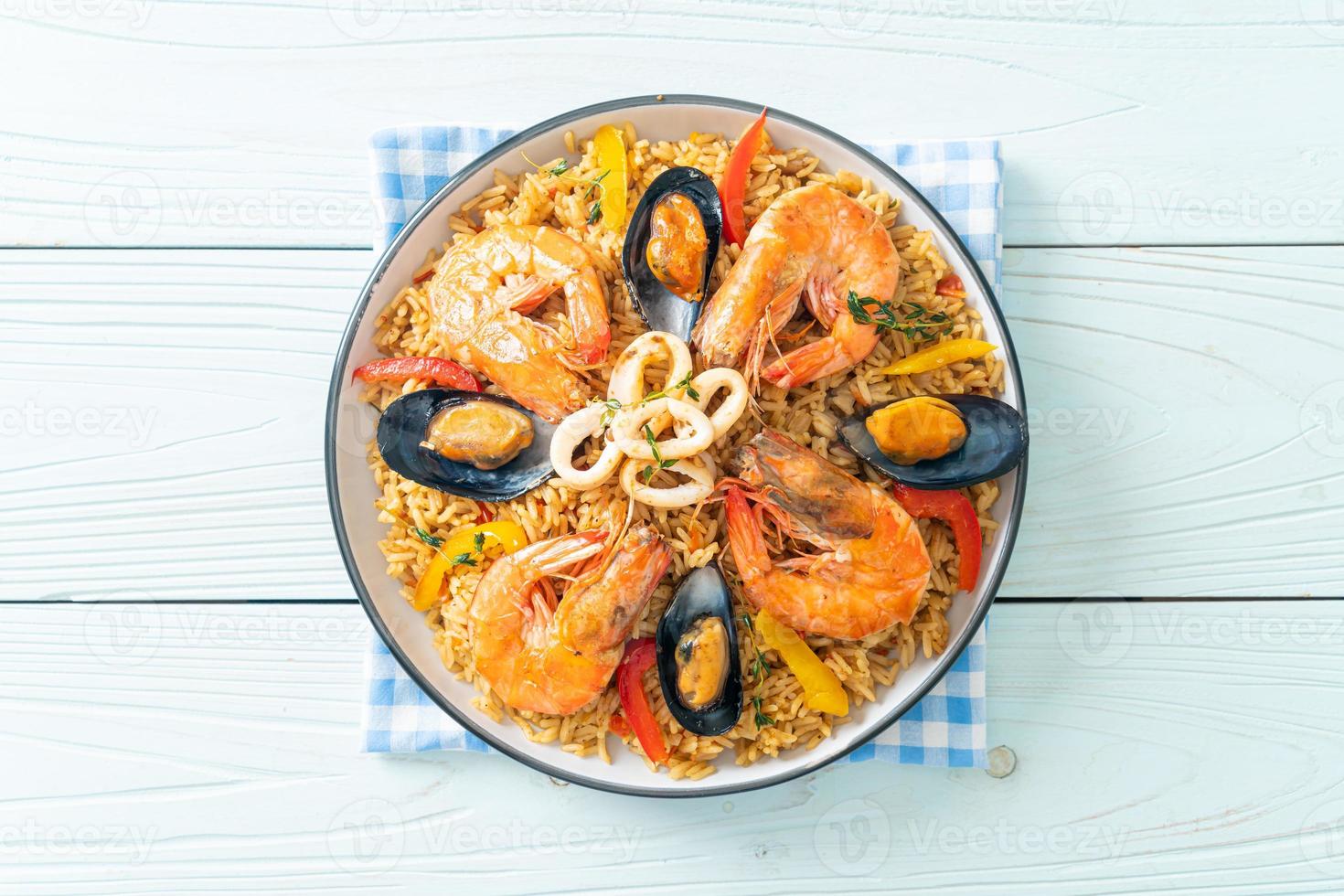 Meeresfrüchte-Paella mit Garnelen, Venusmuscheln, Miesmuscheln auf Safranreis foto