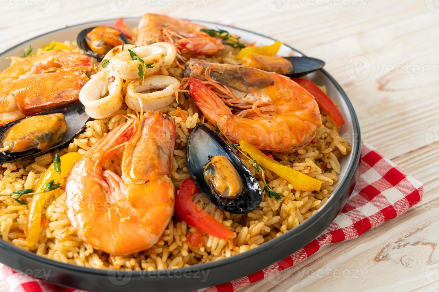 Meeresfrüchte-Paella mit Garnelen, Venusmuscheln, Miesmuscheln auf Safranreis foto