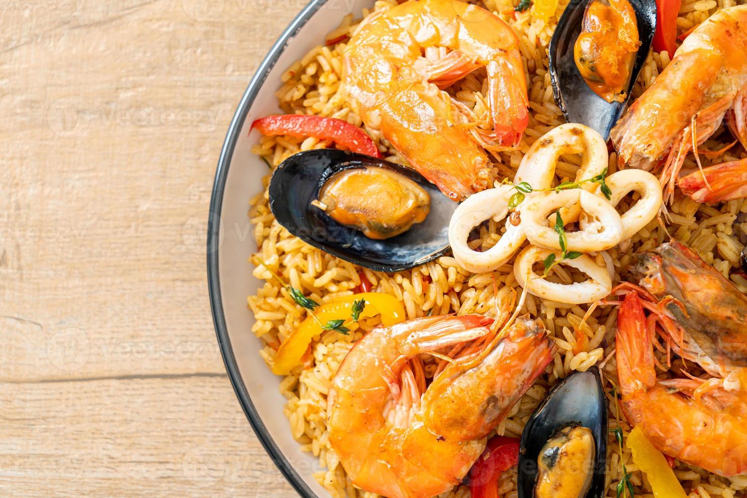 Meeresfrüchte-Paella mit Garnelen, Venusmuscheln, Miesmuscheln auf Safranreis foto