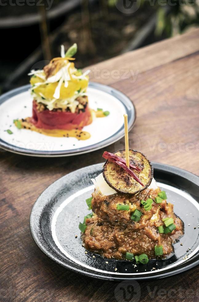 vegane Quinoa-Kuchen mit sizilianisch gerösteten Auberginen und scharfer Paprikasauce Gourmet-Tapas Vorspeisen-Snack foto