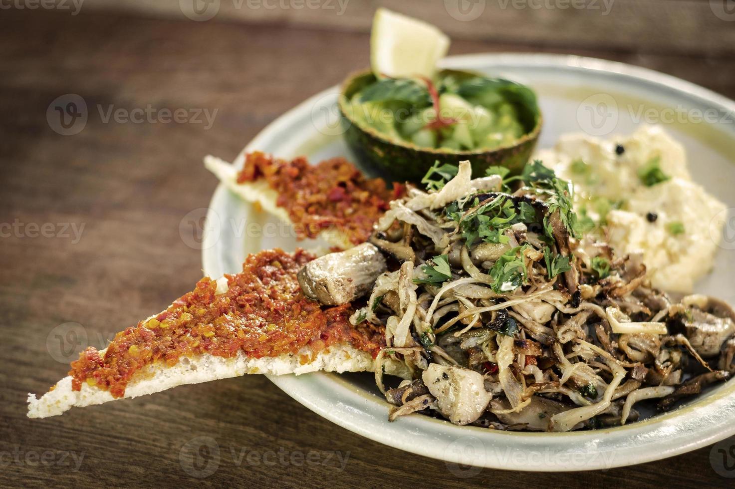 moderner mexikanischer Brunch aus gebratenen Champignons mit Guacamole und würzigem Paprika-Toast und Rührei foto