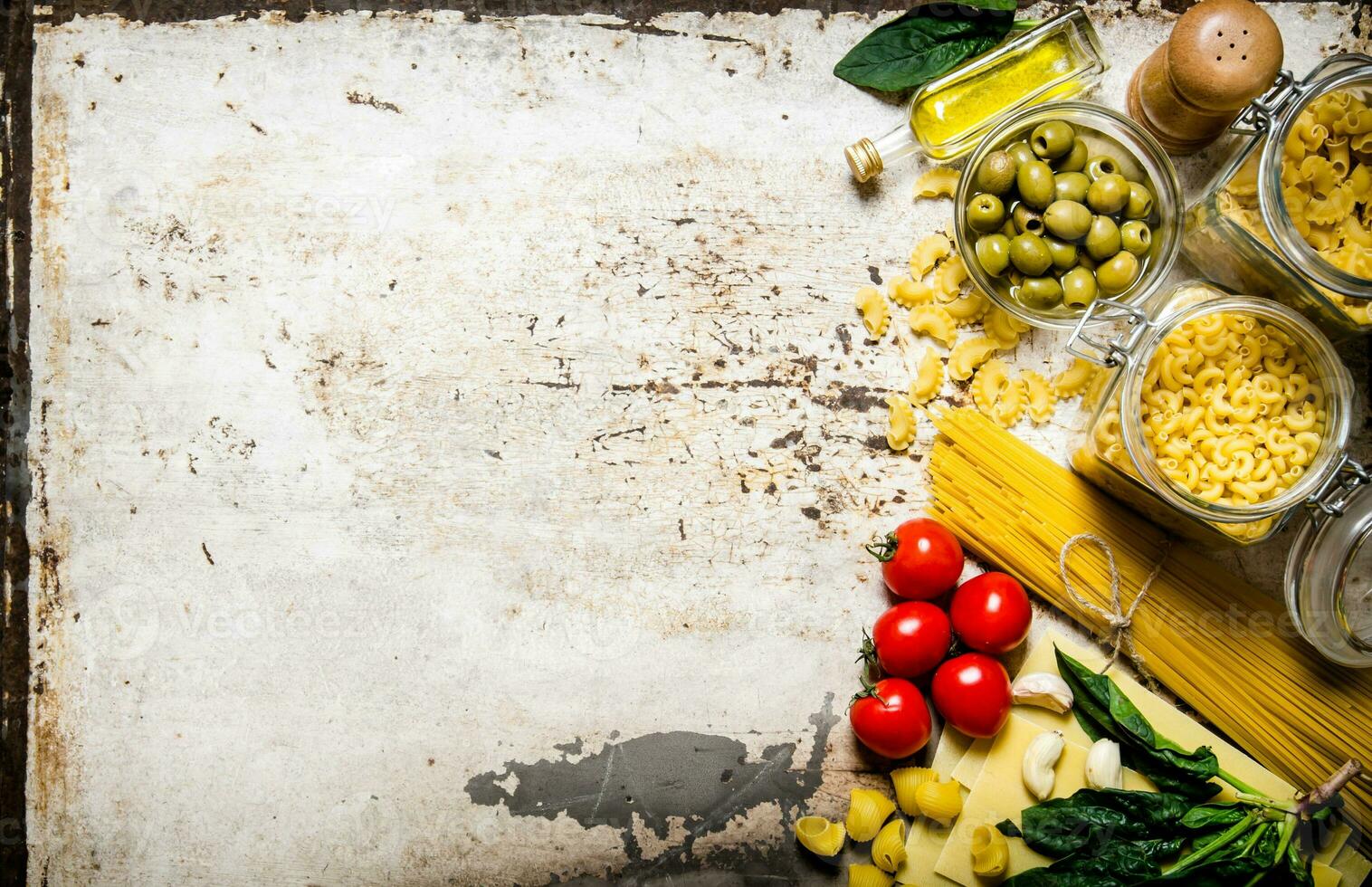 Pasta Hintergrund. ein Menge von anders Pasta, Oliven, Tomaten, Öl und Kräuter. foto