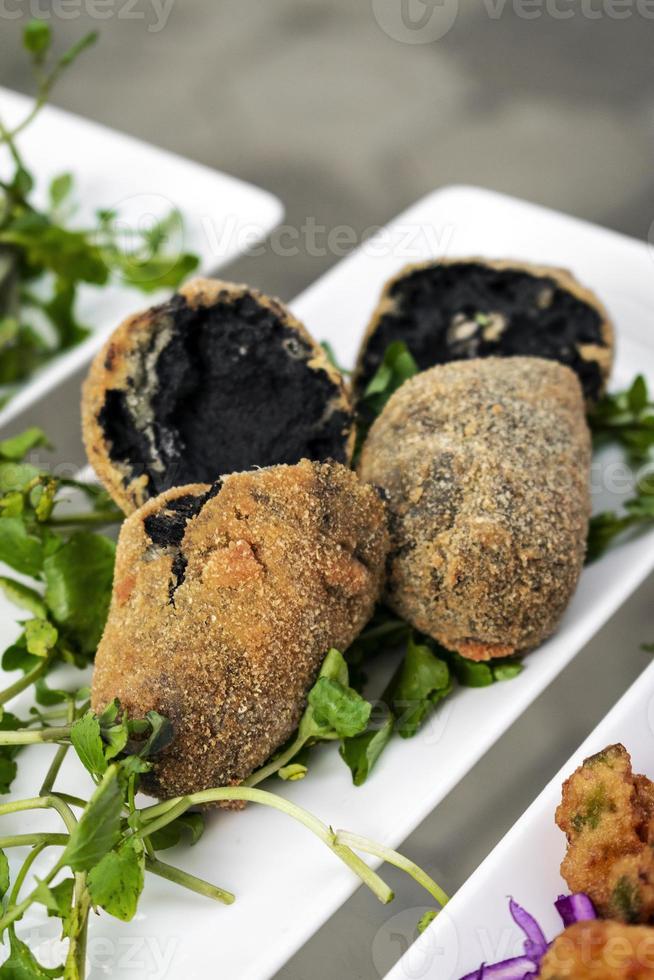 portugiesischer schwarzer Tintenfisch gebratene Kroketten Snack-Food-Vorspeise foto