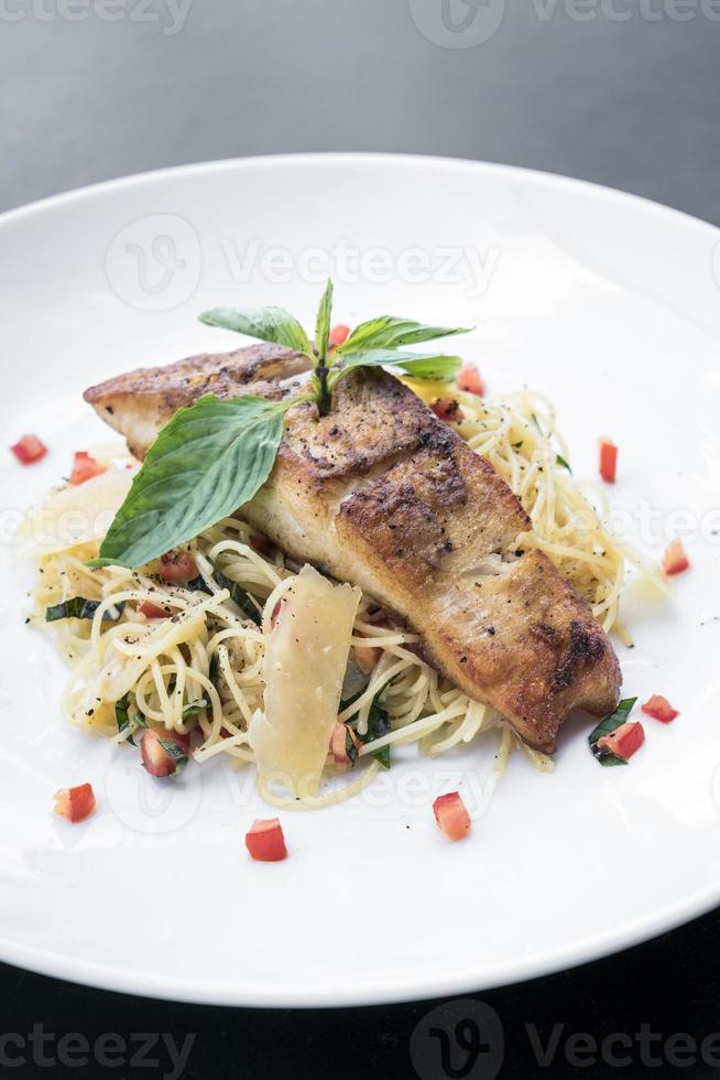 frisches Kabeljaufilet auf gemischtem Gemüse und Parmesan Spaghetti Pasta foto