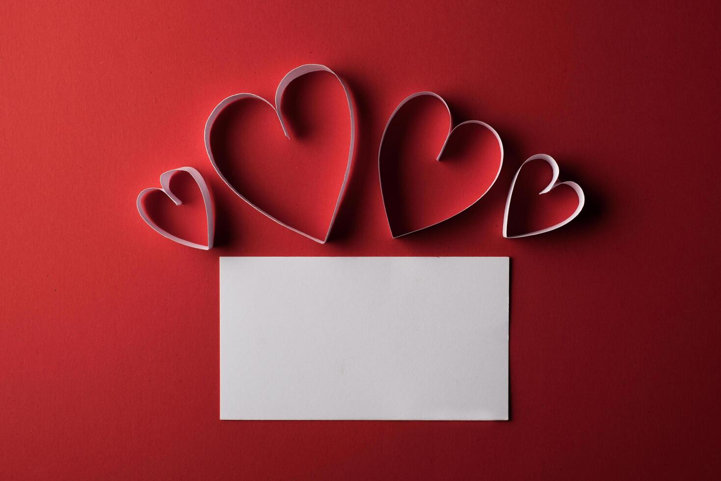 rotes Herzpapier und leer mit Anmerkungskarte auf rotem Hintergrund. foto