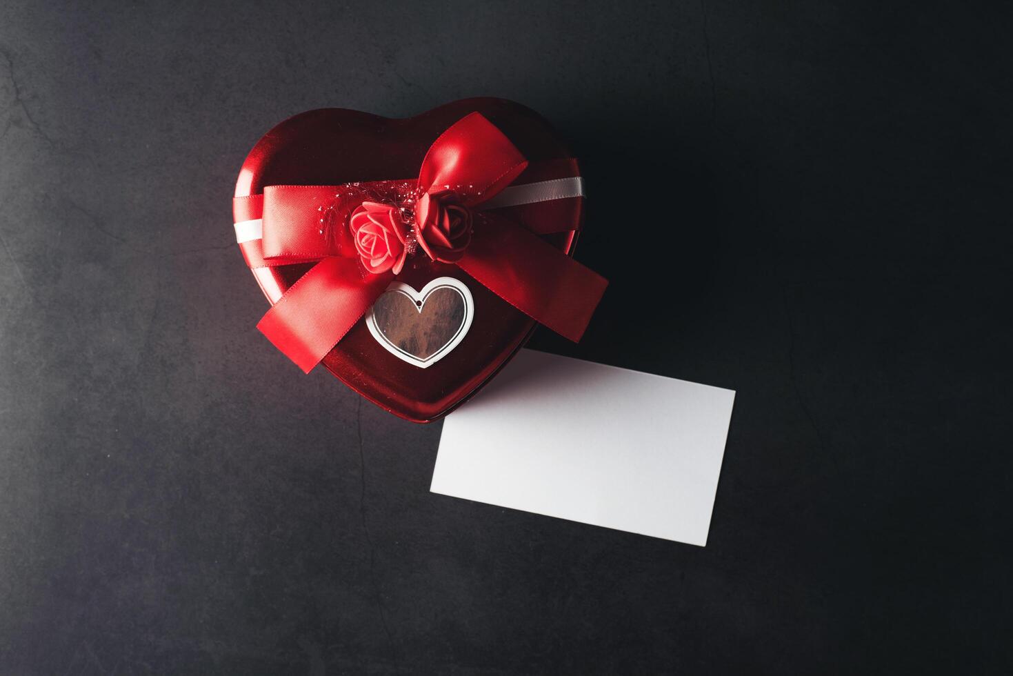 herzförmige Geschenkbox mit leerer Anmerkungskarte, Valentinstag. foto