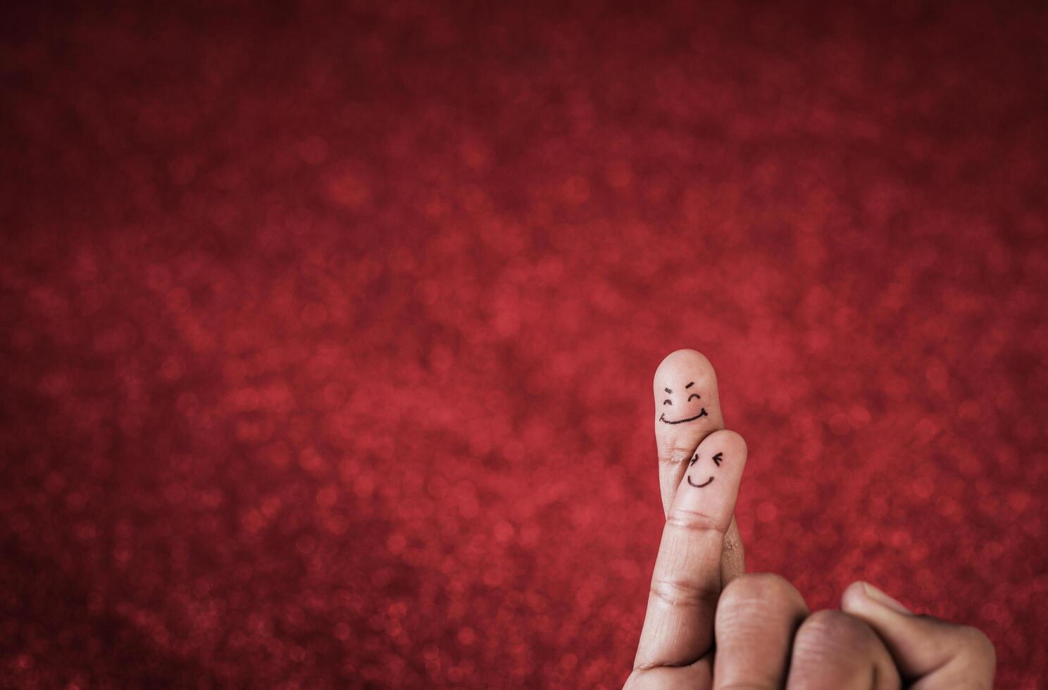 Finger mit Emotion auf rotem Hintergrund. foto