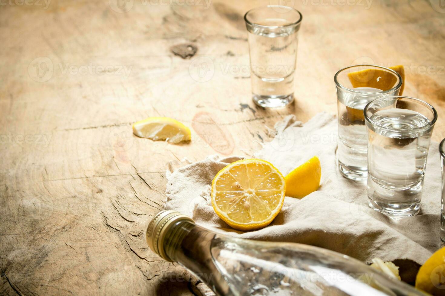 Flasche von Wodka mit Schuss Brille und Zitrone. foto