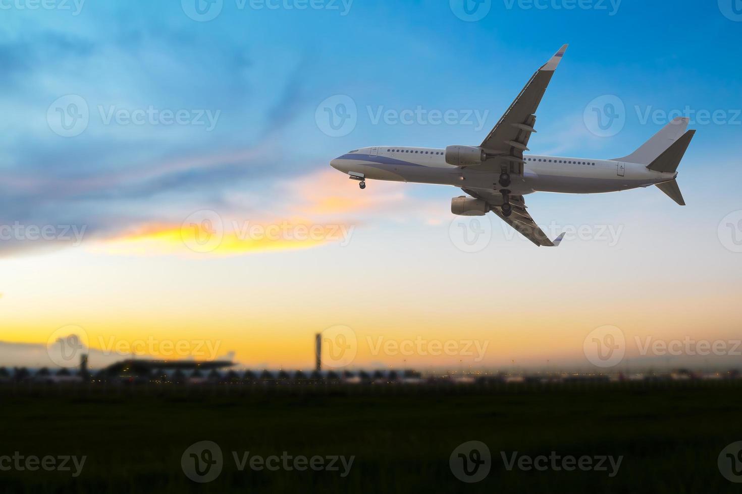 Verkehrsflugzeug fliegt bei Sonnenuntergang über den Flughafen foto