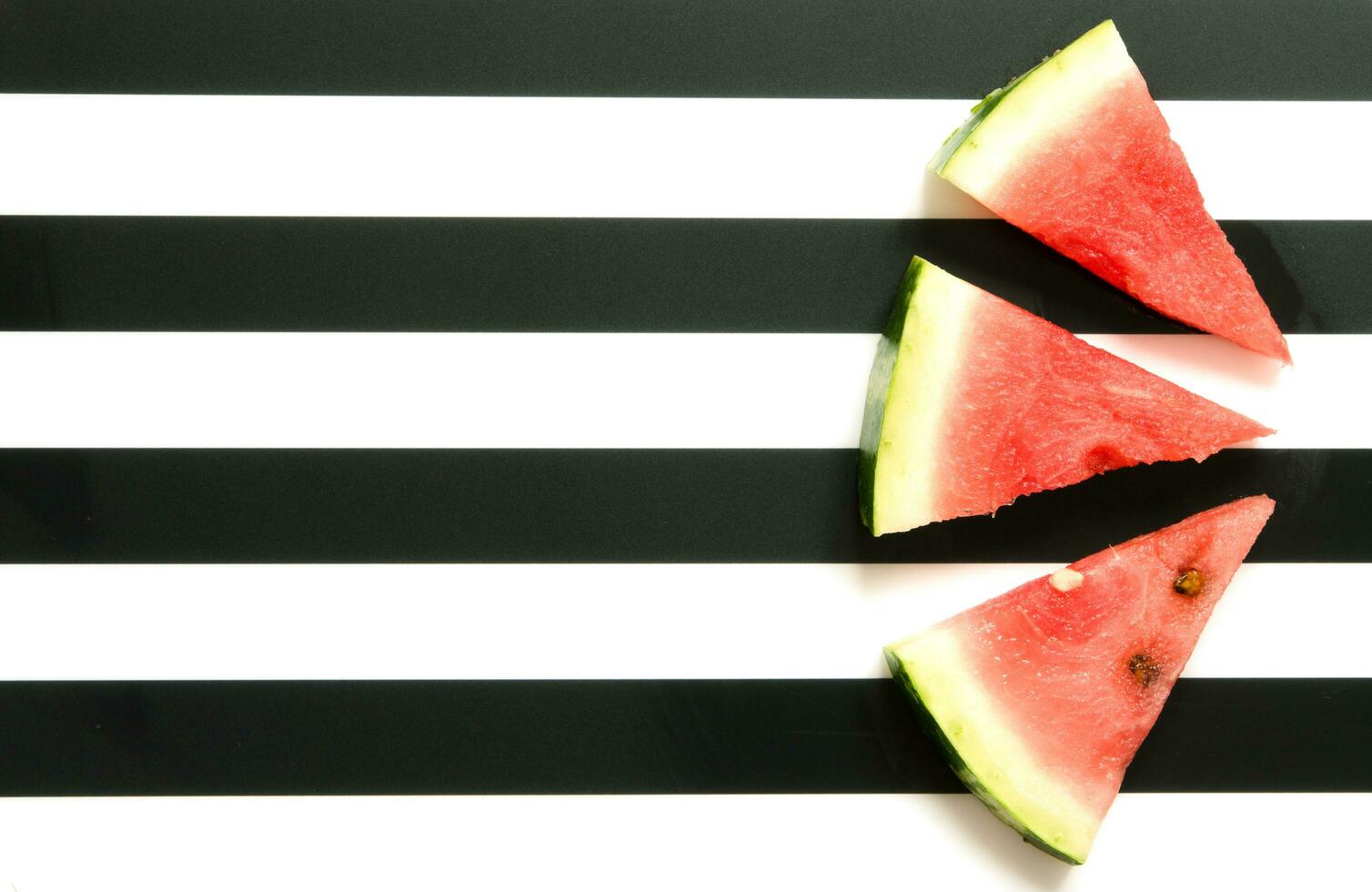 frisch rot Wassermelone Scheibe auf gestreift Hintergrund. Sommer- Konzept. oben Sicht, eben legen. - - Bild foto