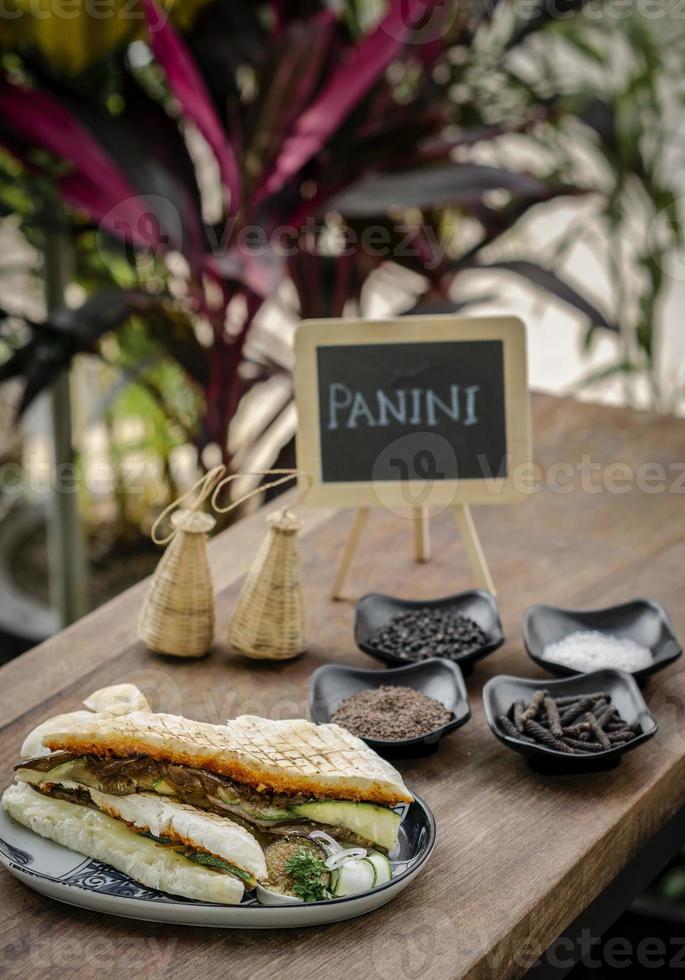 Vegan geröstetes Gemüse geröstetes Panini-Sandwich in rustikalem Gartentisch im Freien auf Sizilien foto