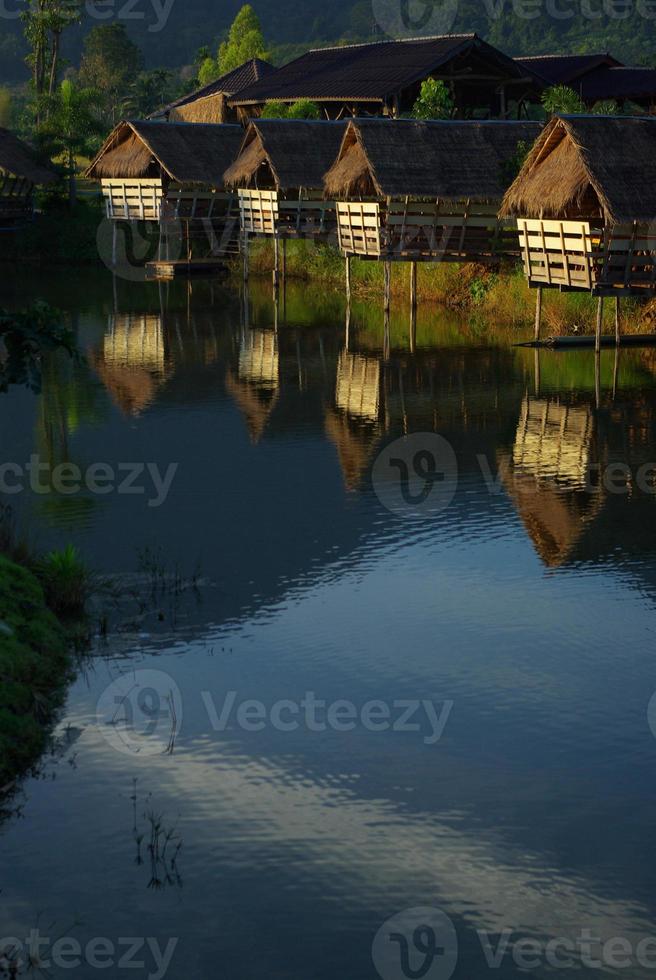 im Morgenlicht kleine Hütten am See und Bergblick foto