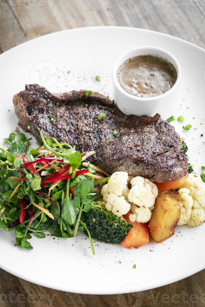 Premium Rindersteak mit gedünstetem Gemüse und Pilzsauce Gourmet-Menü auf weißem Teller foto