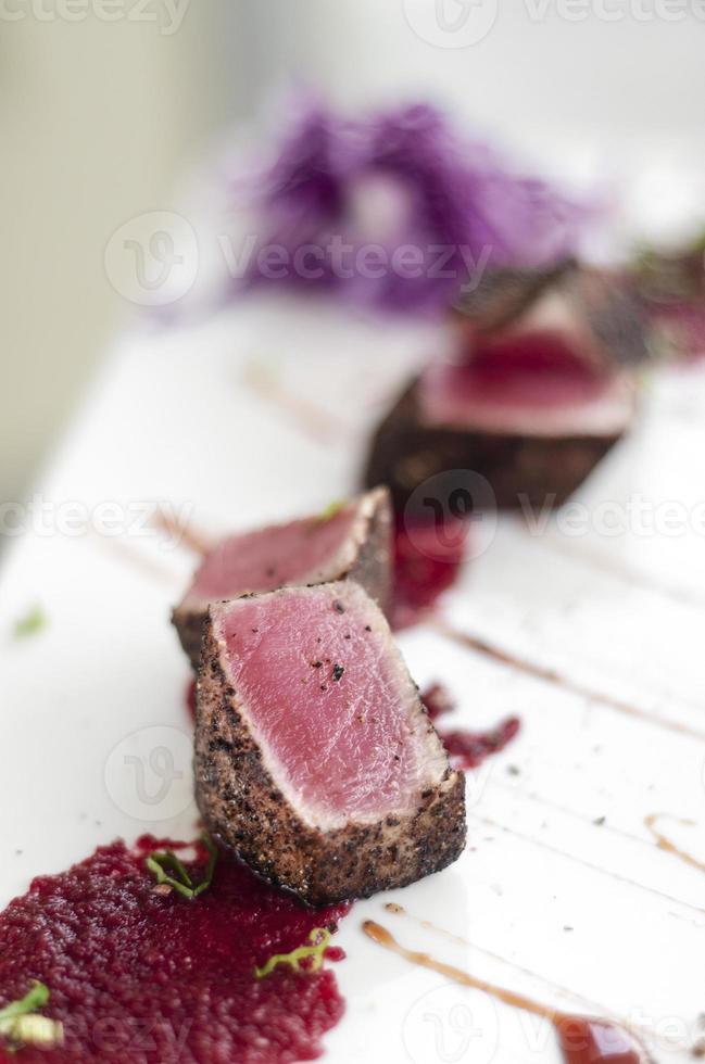 Gourmet gebratener Thunfisch in schwarzer Pfefferkruste mit roter Beete und Himbeercoulis foto