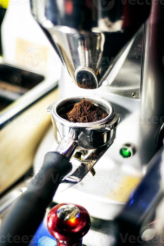 Zubereitung von Espresso-Kaffee Nahaufnahme Detail mit moderner Café-Kaffeemühle-Maschine foto